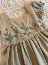 Load image into Gallery viewer, Beige fabric with floral embroidery on a textured surface