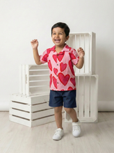 Load image into Gallery viewer, Child wearing a pink shirt with red hearts and denim shorts. Pure cotton shirt with quirky print
