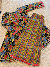 Load image into Gallery viewer, Colorful patterned fabric with floral and striped designs on a beige carpet.

