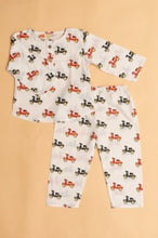 Load image into Gallery viewer, Children's pajama set with scooter pattern on a beige background
