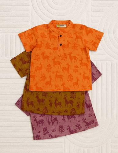 Children's outfit with orange shirt and patterned pants on a textured white background